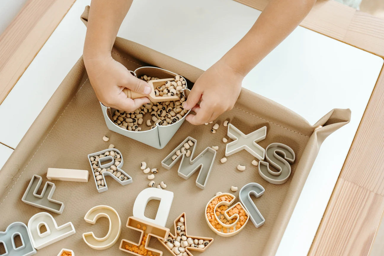 Bandeja sensorial plegable de cuero vegano color beige neutro con cierres de clip en las esquinas.